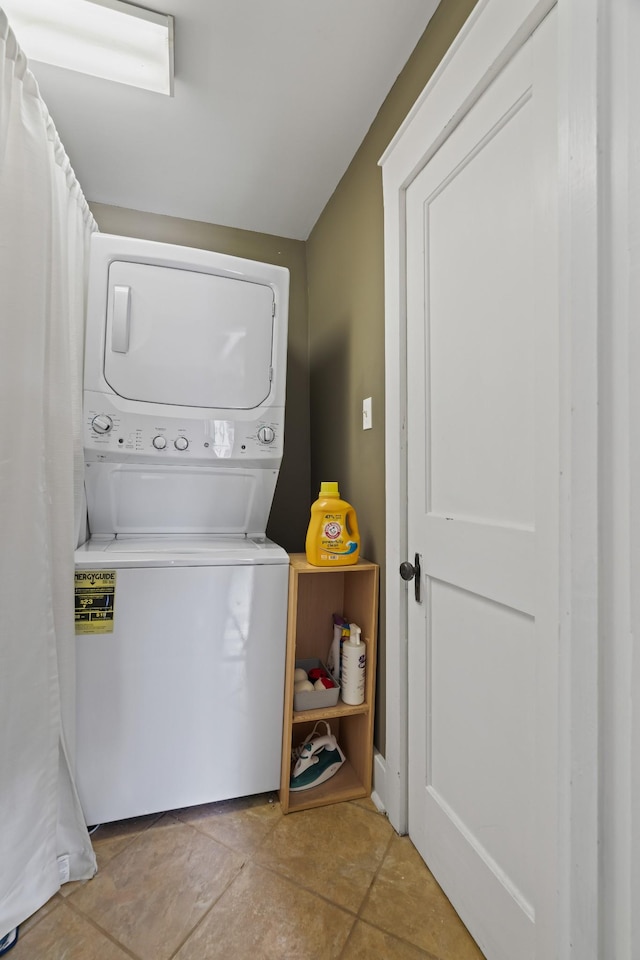 laundry area featuring light tile patterned flooring and stacked washing maching and dryer