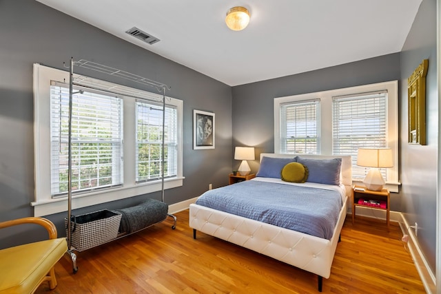 bedroom with hardwood / wood-style floors and multiple windows