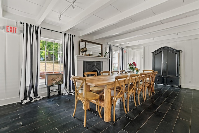 dining room with beamed ceiling and track lighting