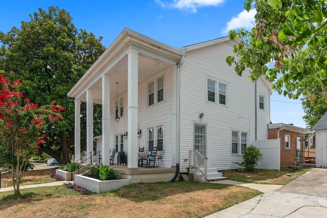 neoclassical home with a front lawn and a porch