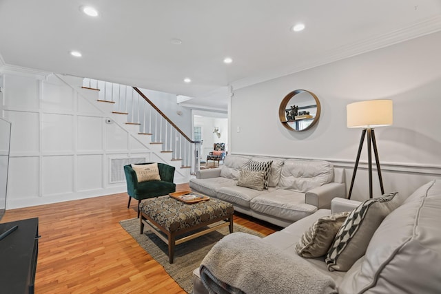 living room featuring wood-type flooring and crown molding