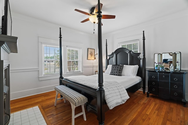 bedroom with ceiling fan, dark hardwood / wood-style floors, and ornamental molding