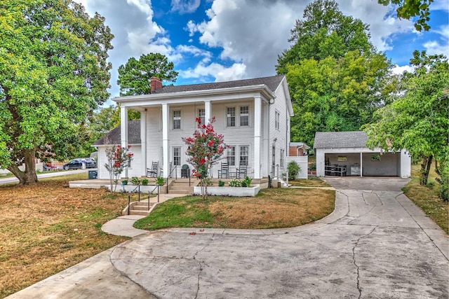 view of front facade with a front yard, a garage, and an outdoor structure