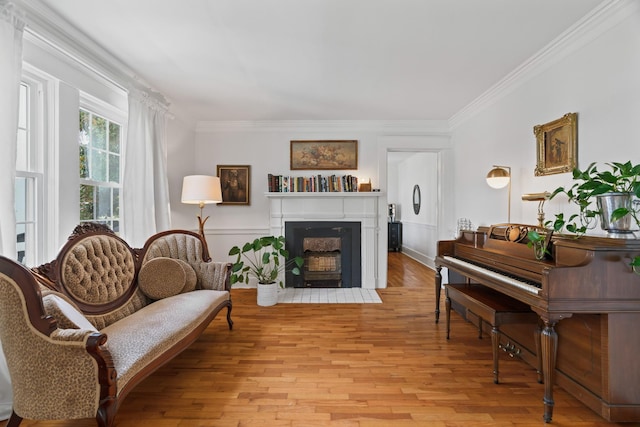 living area featuring light wood-type flooring and crown molding