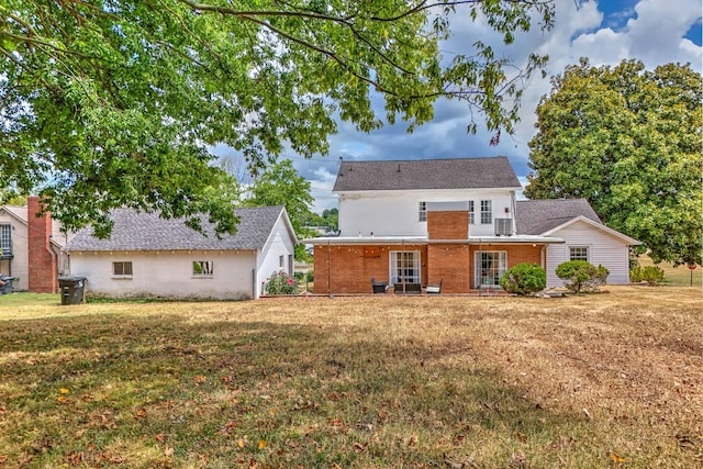 rear view of property featuring a lawn