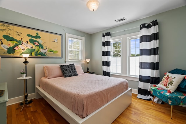 bedroom featuring multiple windows and wood-type flooring