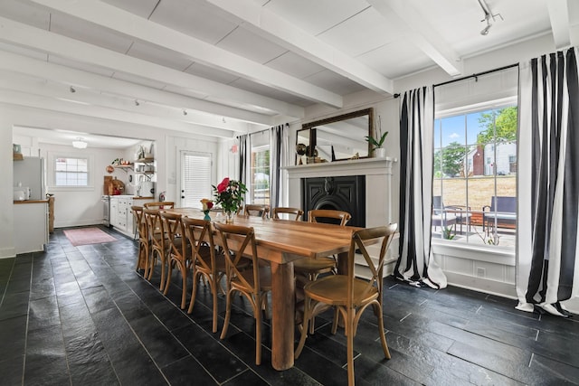 dining area featuring plenty of natural light and beam ceiling