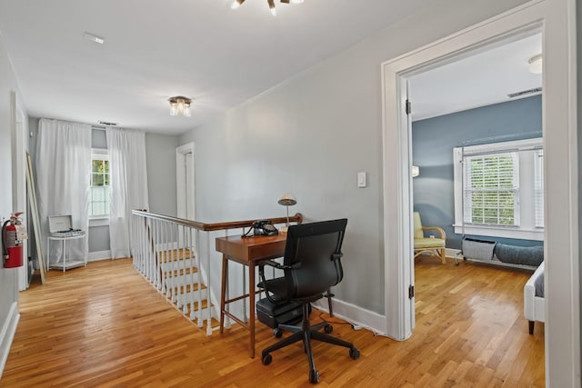 home office with light hardwood / wood-style flooring