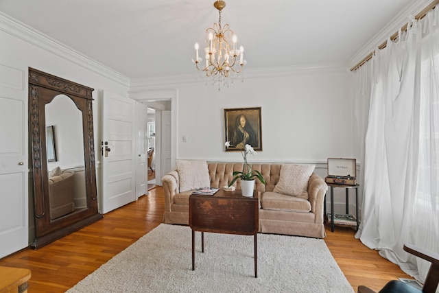 living room featuring a chandelier, wood-type flooring, and ornamental molding