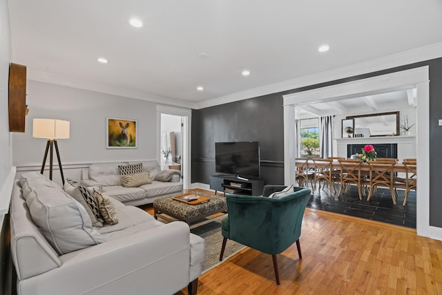 living room featuring crown molding and light hardwood / wood-style floors