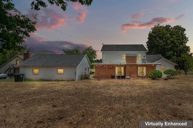 back house at dusk with a yard