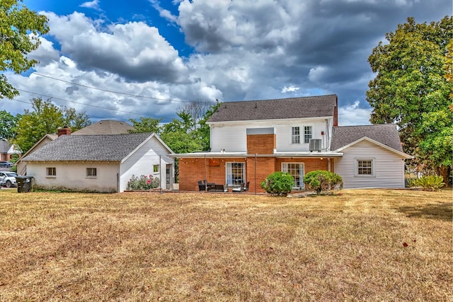 rear view of property featuring a lawn