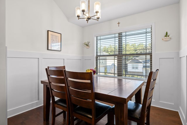 dining space with dark wood-type flooring and a chandelier