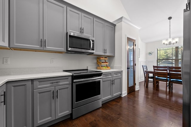 kitchen with dark hardwood / wood-style flooring, stainless steel appliances, a chandelier, gray cabinets, and hanging light fixtures