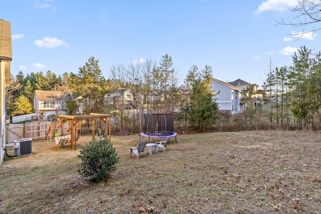 view of yard with a playground, a trampoline, and central AC