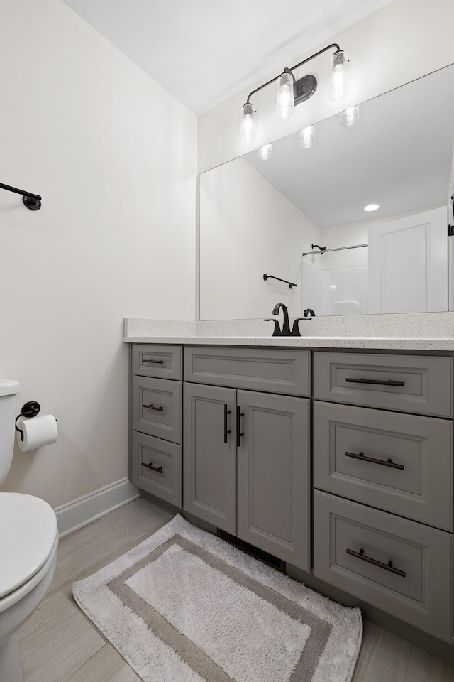 bathroom with vanity, toilet, and a shower