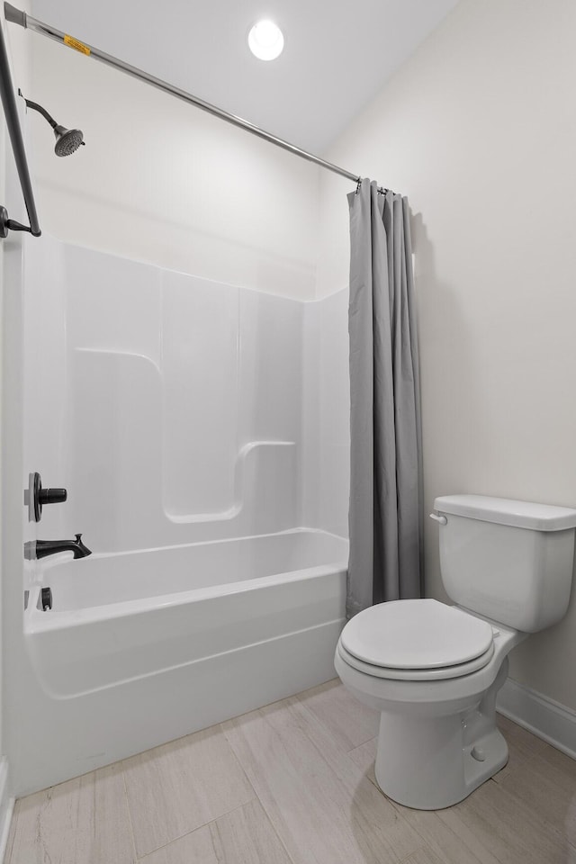 bathroom featuring toilet and shower / bathtub combination with curtain