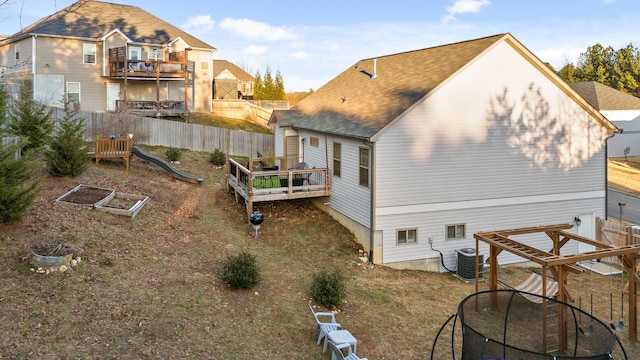 back of property with a playground, central air condition unit, a deck, and a trampoline