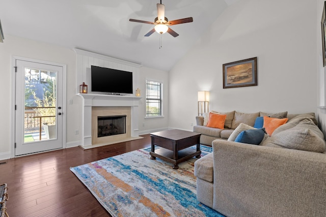 living room featuring ceiling fan, a premium fireplace, dark wood-type flooring, and lofted ceiling