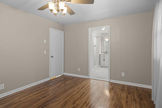 unfurnished bedroom with ceiling fan, dark wood-type flooring, and connected bathroom