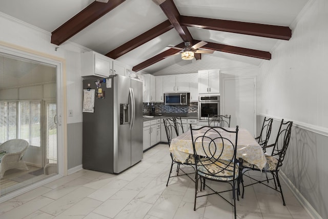 kitchen with appliances with stainless steel finishes, decorative backsplash, white cabinetry, and lofted ceiling with beams