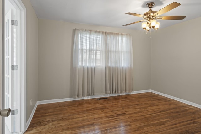 empty room with ceiling fan and dark hardwood / wood-style flooring