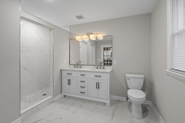 bathroom with toilet, vanity, and a tile shower