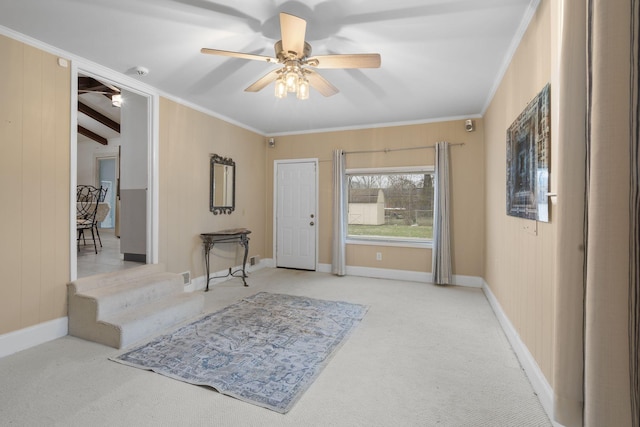 foyer featuring ceiling fan, light carpet, beamed ceiling, and crown molding