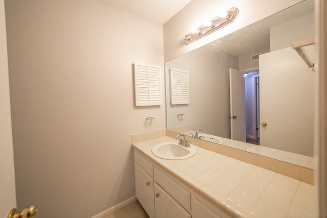 bathroom with vanity and a textured ceiling