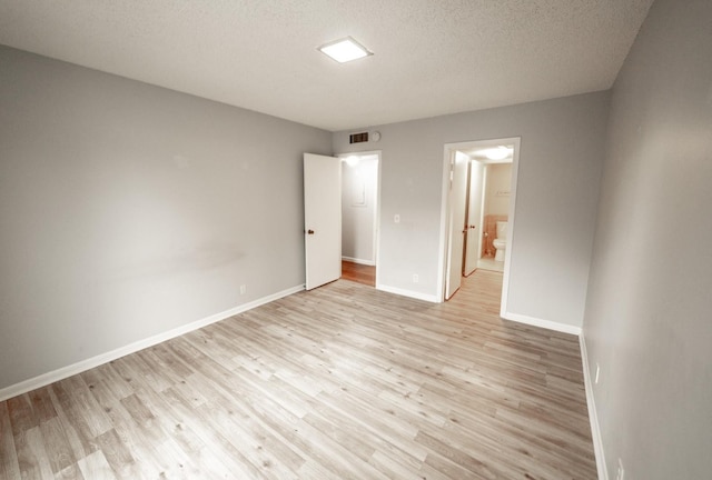 empty room featuring light hardwood / wood-style floors and a textured ceiling