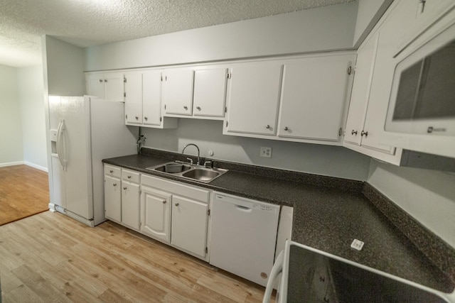 kitchen featuring light wood-type flooring, a textured ceiling, white appliances, sink, and white cabinetry