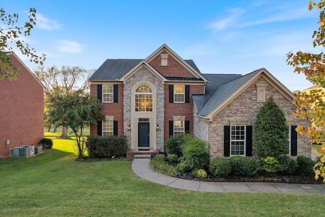 view of front of property with central AC and a front yard