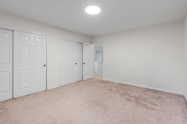 unfurnished bedroom with carpet flooring and multiple closets