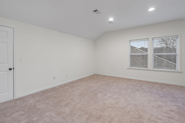 carpeted empty room with lofted ceiling