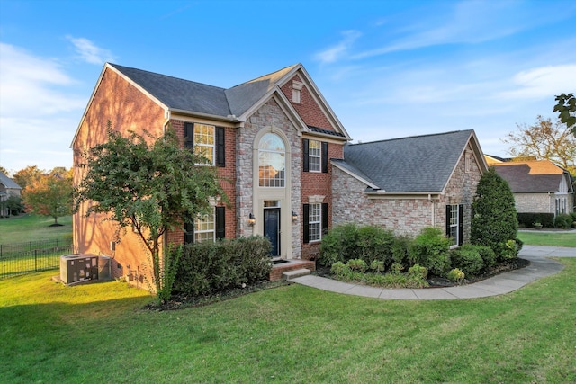 colonial-style house with a front yard and central air condition unit