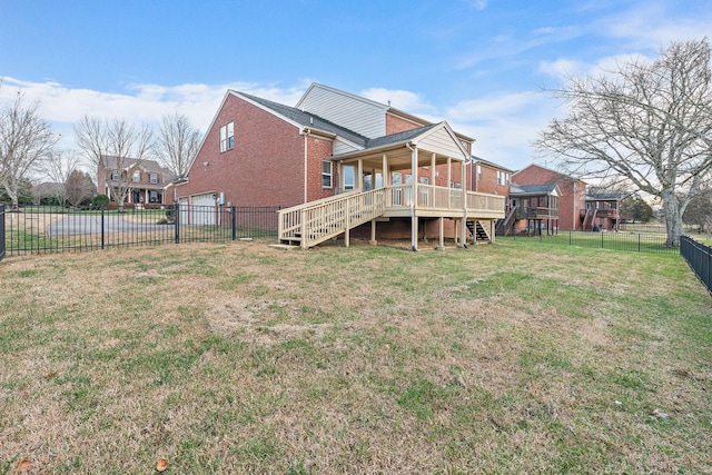 back of property featuring a yard, a garage, and a wooden deck