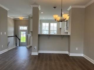 kitchen featuring kitchen peninsula, a breakfast bar area, hanging light fixtures, and ornamental molding