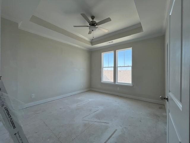 empty room with a tray ceiling, ceiling fan, and ornamental molding