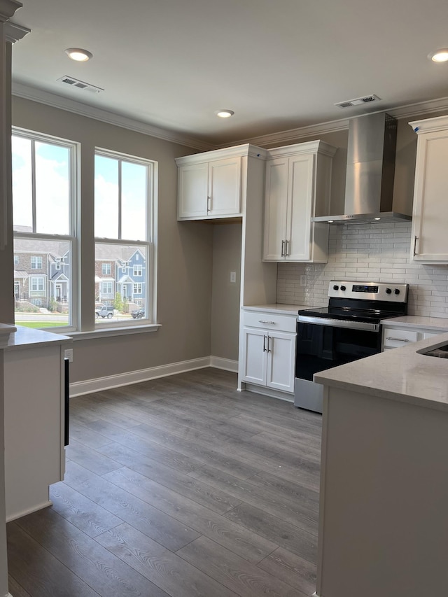 kitchen featuring white cabinets, hardwood / wood-style flooring, wall chimney exhaust hood, and stainless steel range with electric cooktop