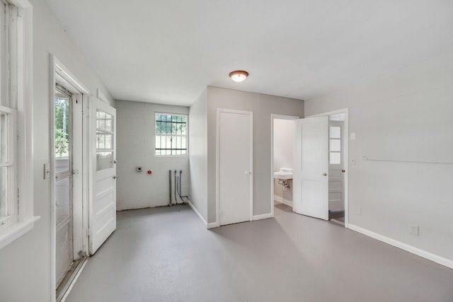 unfurnished bedroom featuring radiator heating unit and concrete floors