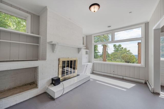 unfurnished living room with concrete flooring, a brick fireplace, baseboard heating, and crown molding