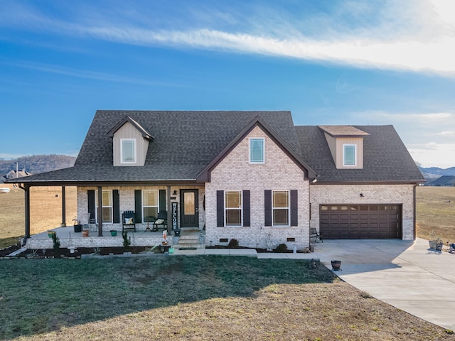 view of front of house featuring a mountain view, a garage, a front lawn, and covered porch