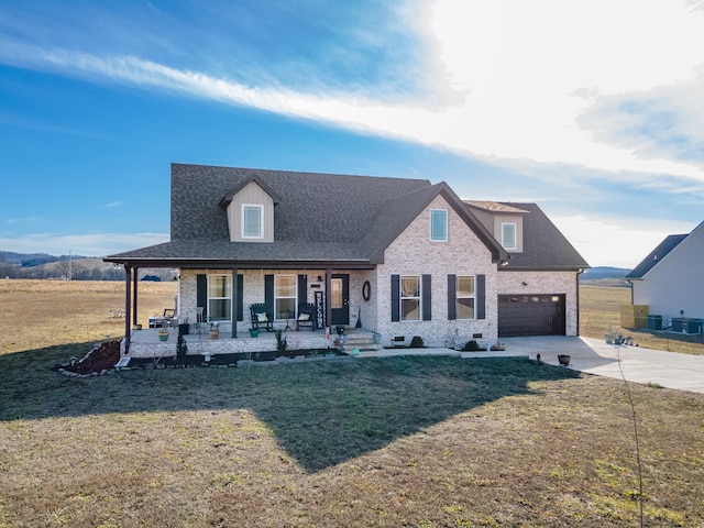 view of front of house with a garage, covered porch, and a front yard