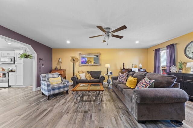 living room featuring ceiling fan and light hardwood / wood-style flooring