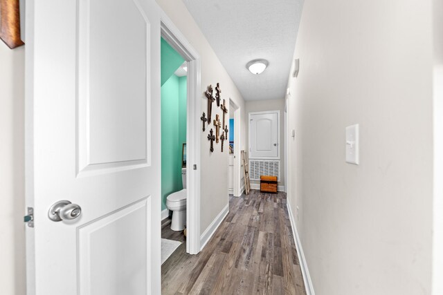 hall with hardwood / wood-style flooring and a textured ceiling