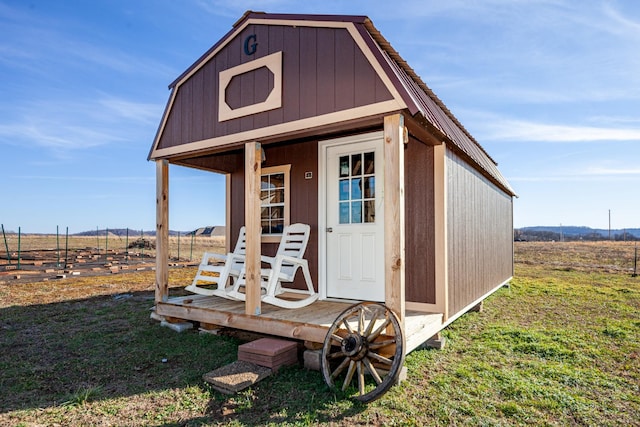 view of outbuilding featuring a rural view and a lawn