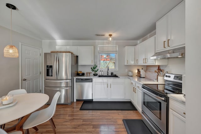 kitchen featuring pendant lighting, sink, stainless steel appliances, white cabinets, and dark hardwood / wood-style flooring