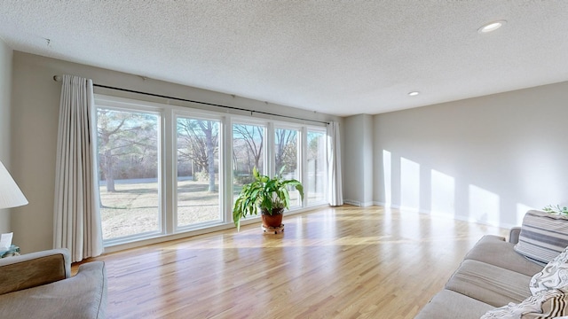 unfurnished living room featuring light hardwood / wood-style floors and a textured ceiling