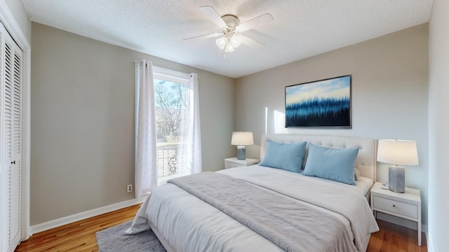 bedroom featuring ceiling fan, a closet, a textured ceiling, and light wood-type flooring