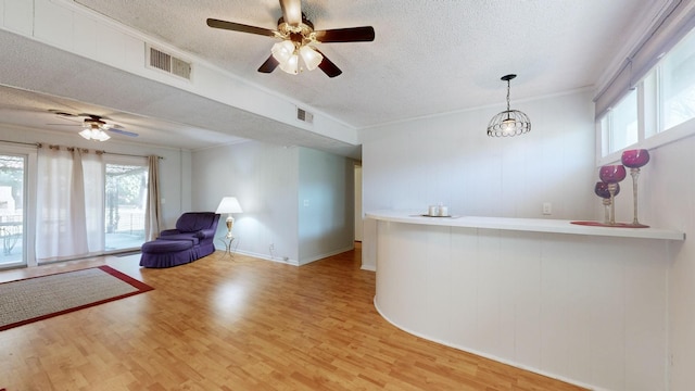 bar featuring a textured ceiling, light wood-type flooring, and crown molding